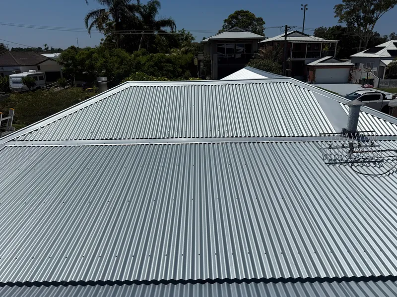 Unpainted corrugated metal roof with the TV antenna and flue in place