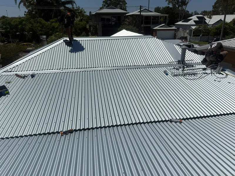 Unpainted corrugated metal roof with the TV antenna refitted on an established home