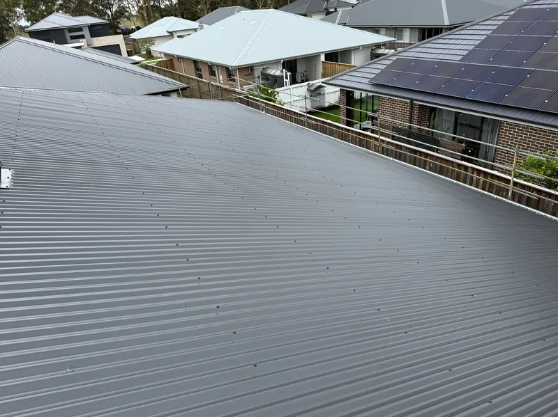Grey corrugated roof with edge protection rail in place