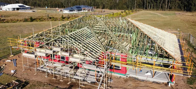 Roof framing in place on a Tingira Heights house, with scaffolding around the walls