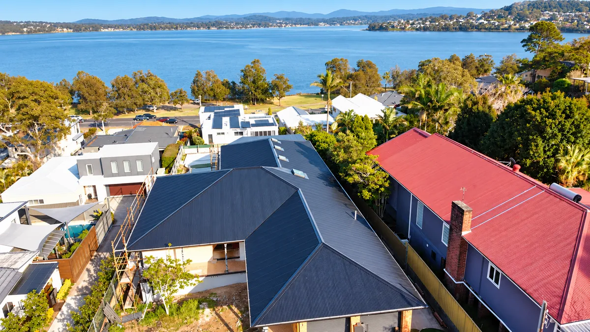 Aerial view of dark roofing, fascia and guttering by Auzsheet Roofing in Warners Bay, looking towards Lake Macquarie